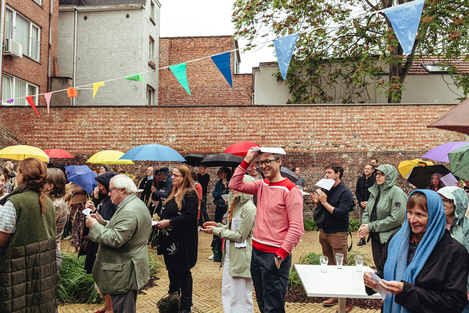 Publiek tijdens opening Hotel Dumont in de regen