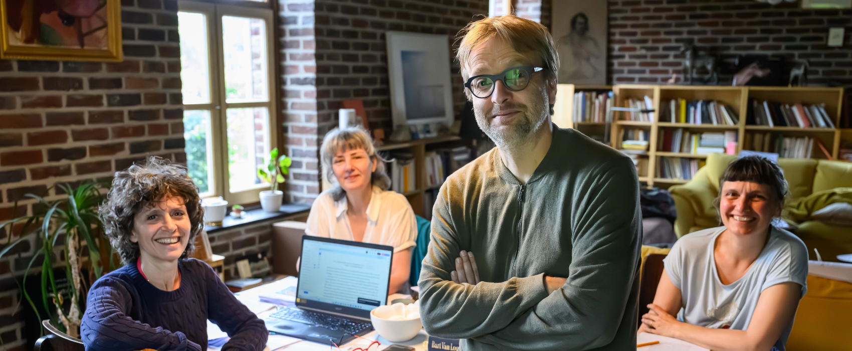 Auteur en vertaalsters rond een tafel, ze kijken naar de camera